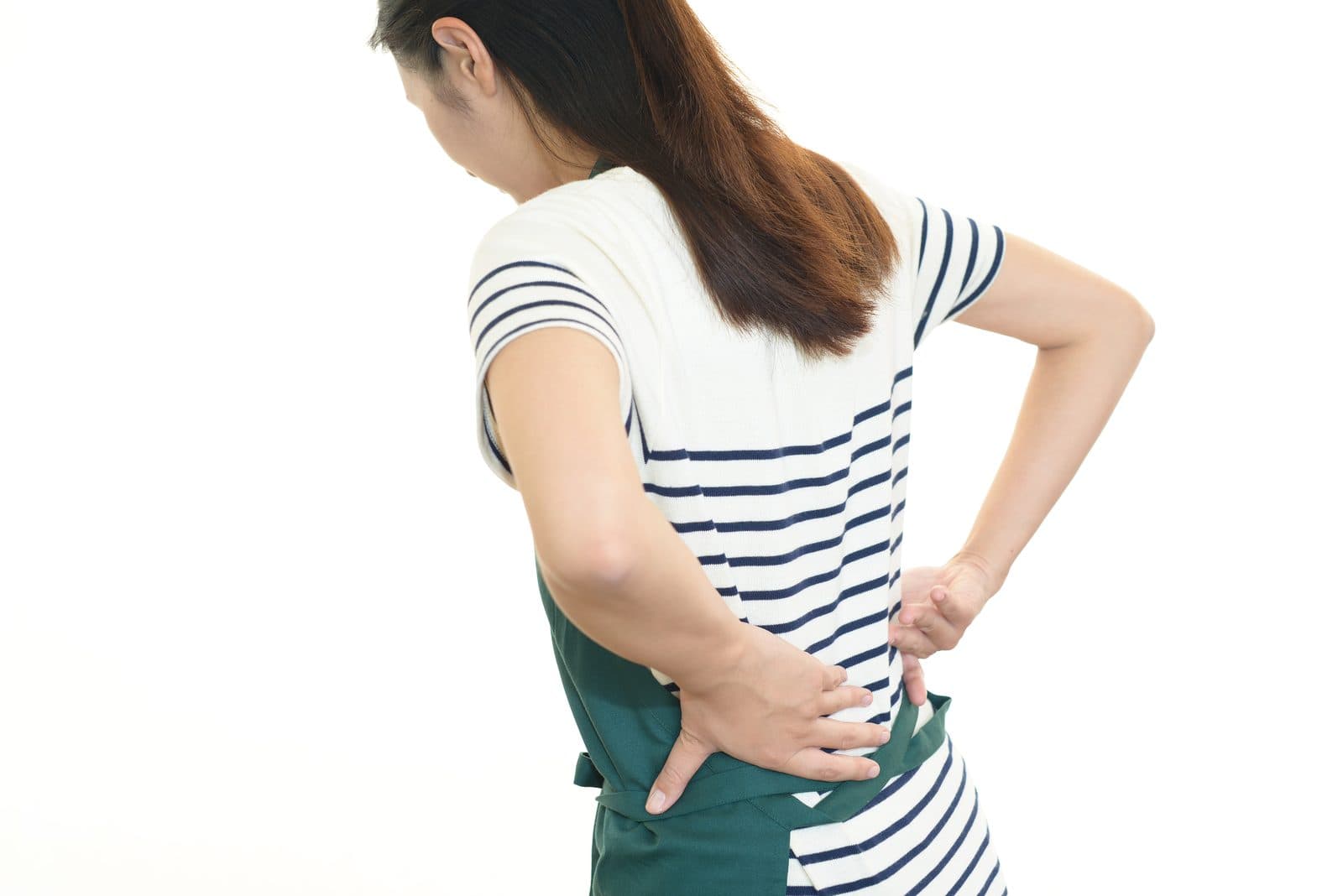 エプロン姿で腰に手をあて、痛みをこらえる人の後ろ姿