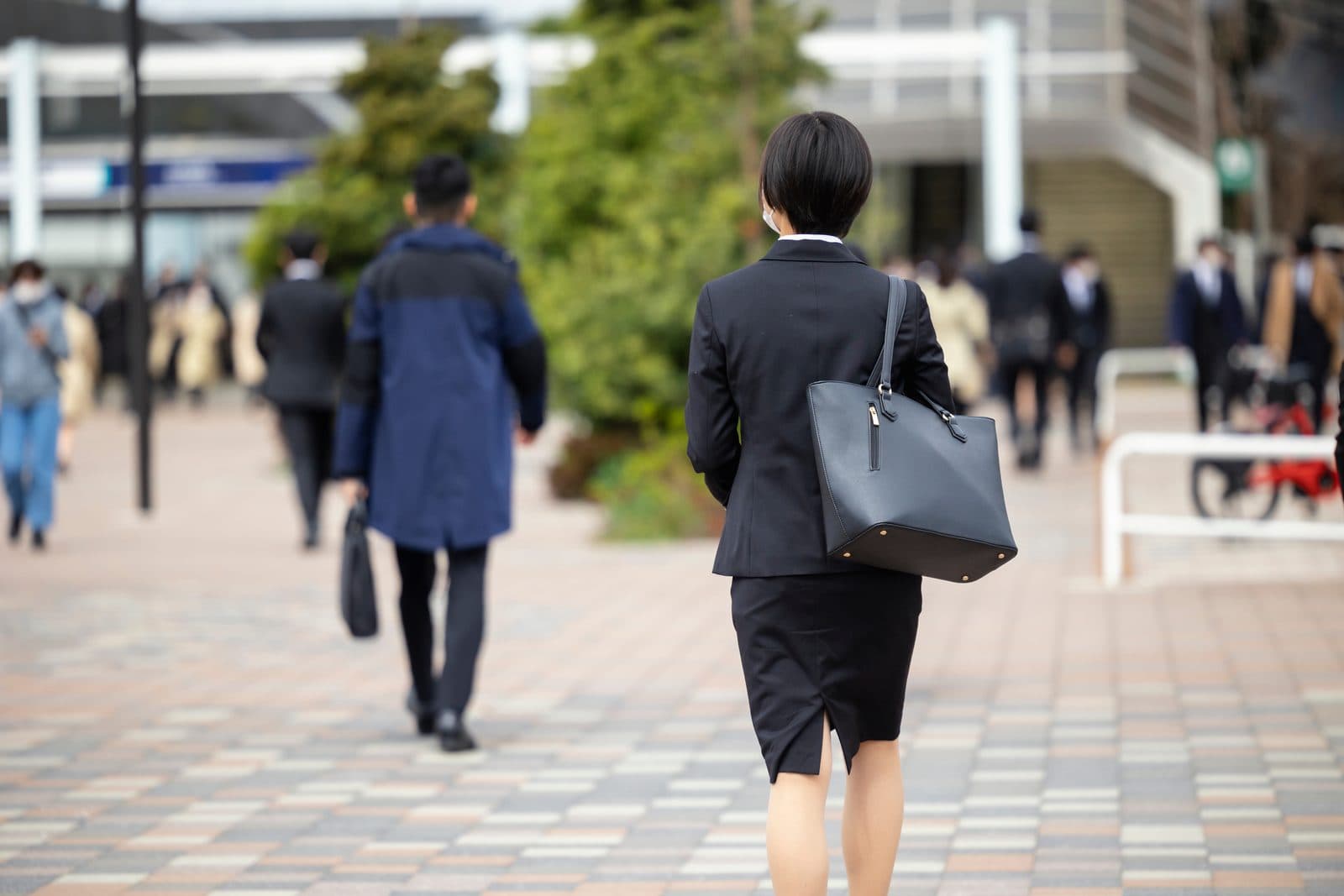 スーツ姿で街を移動する営業担当の後ろ姿