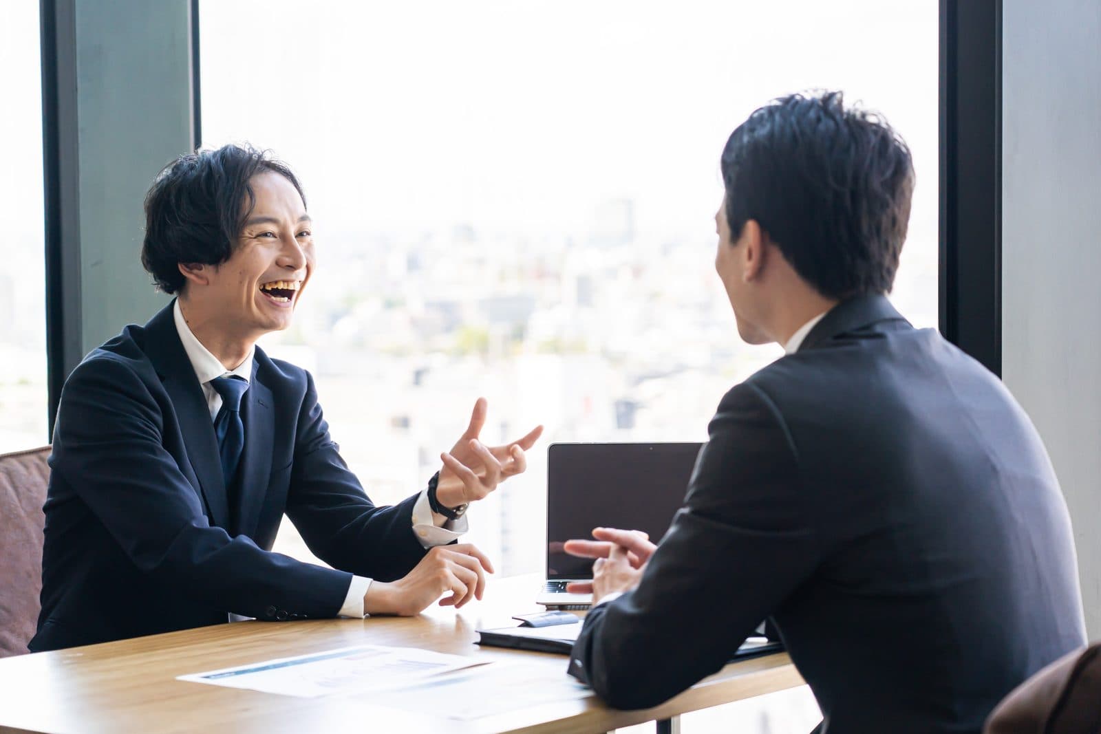 オフィスの打ち合わせスペースで商談をするビジネスパーソン
